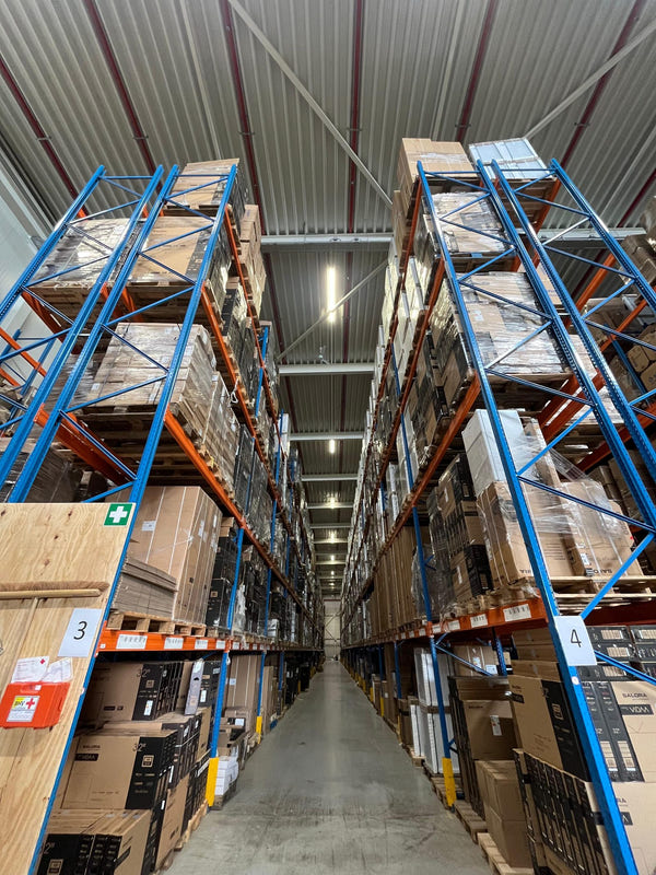 Magazijngang met hoge stellingen vol pallets in het warehouse van Fulfilment Station in Breda